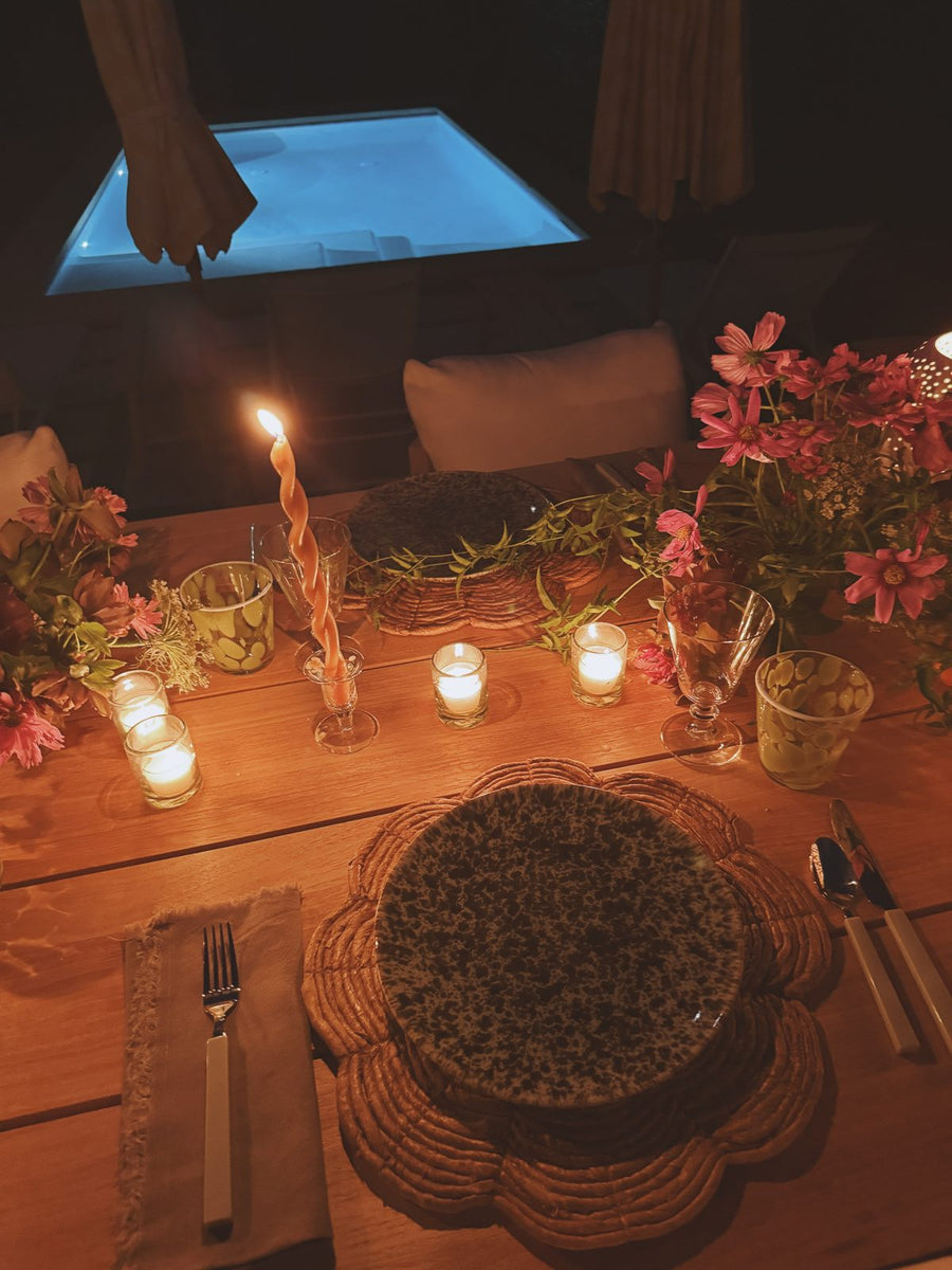 A candlelit table at night by the pool