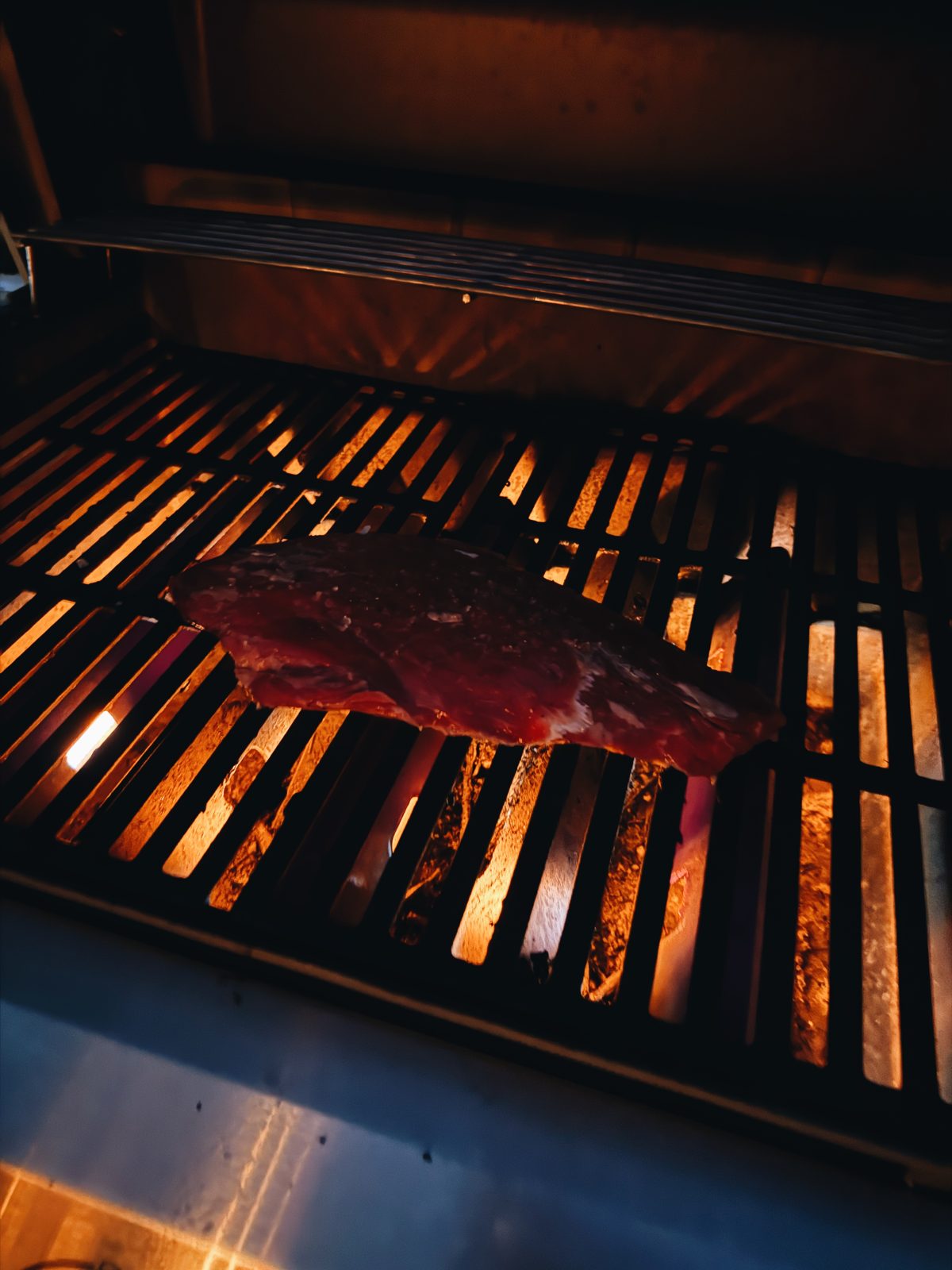 Flank steak charring over a hot grill