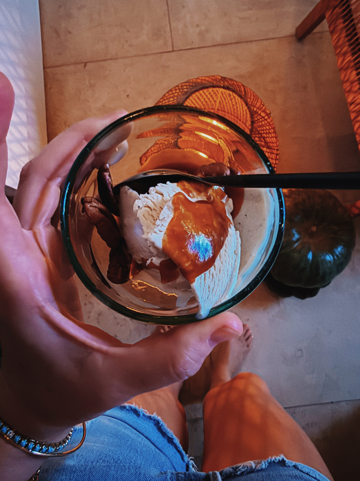 A glass of ice cream with dulce de leche held up over the table
