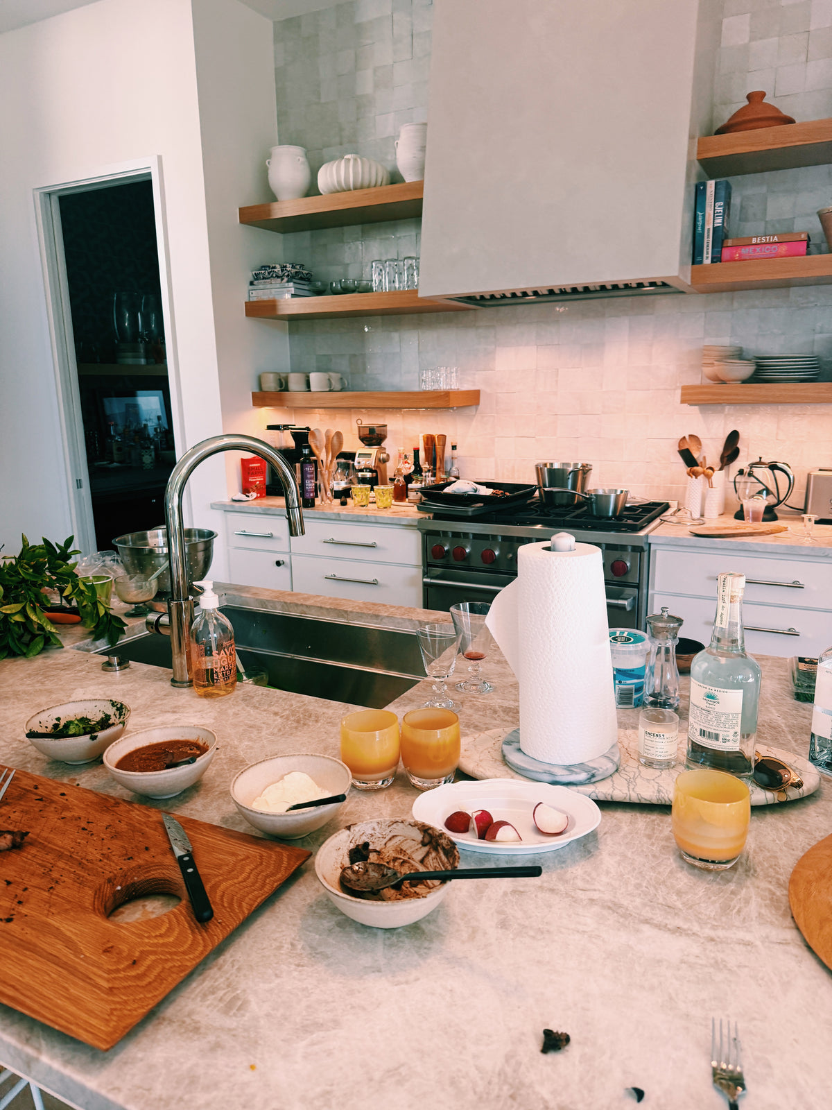 The kitchen the next morning: bowls, glasses and a cutting board left on the counter
