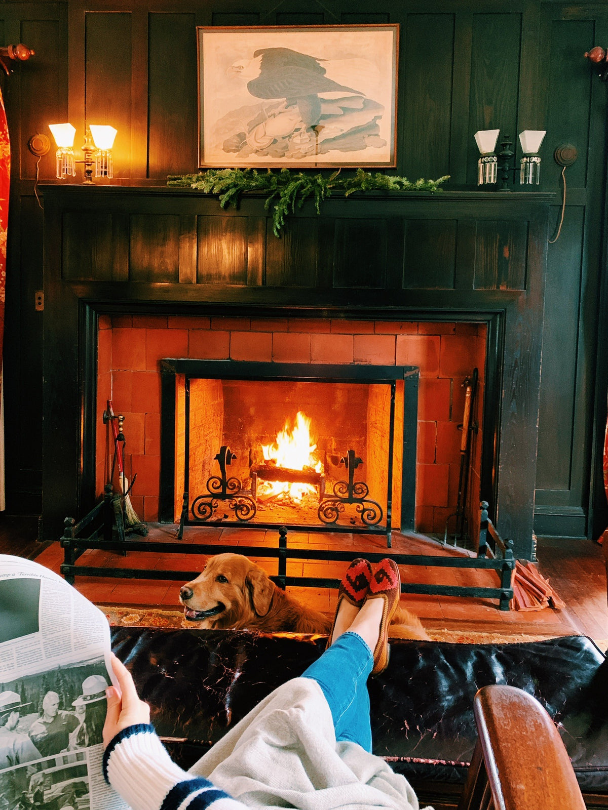 Feet up in front of the fire with the newspaper, the golden retriever on the rug