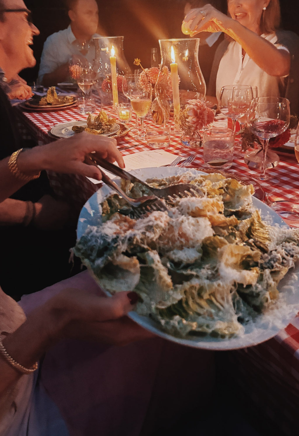 A big platter of salad passed down the candlelit table