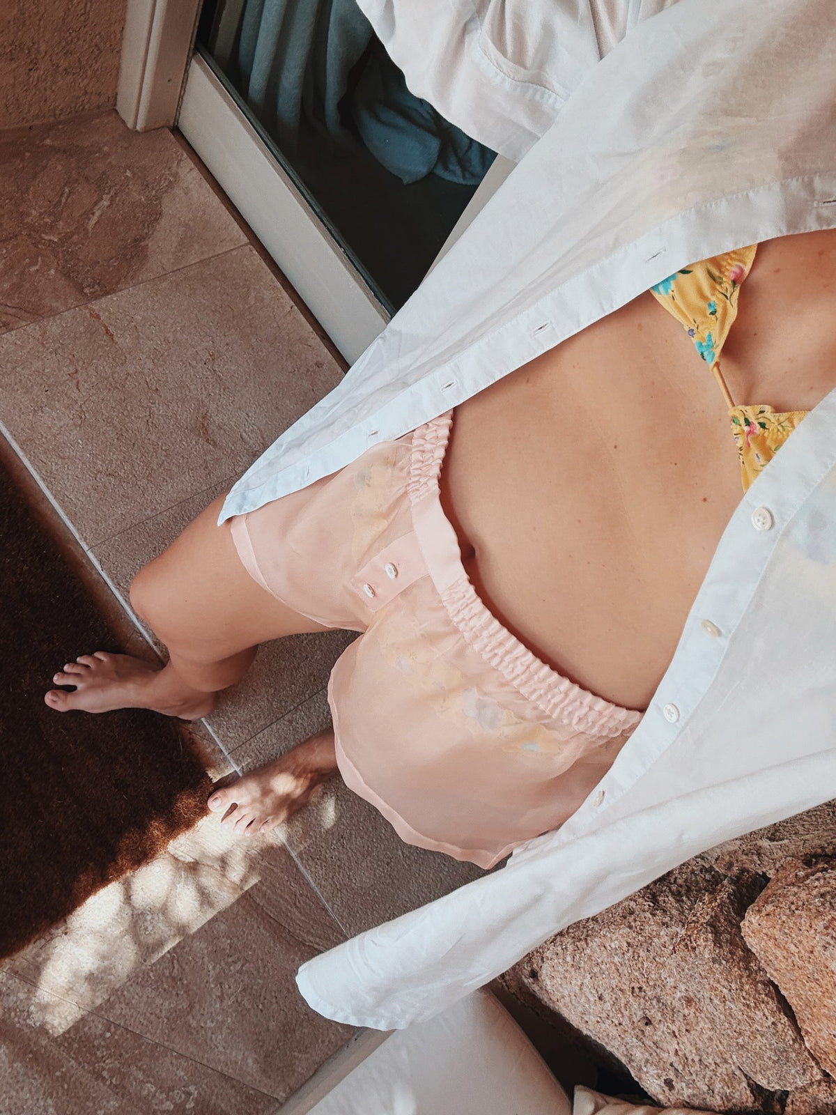 Pink boxers and a white shirt on warm rock