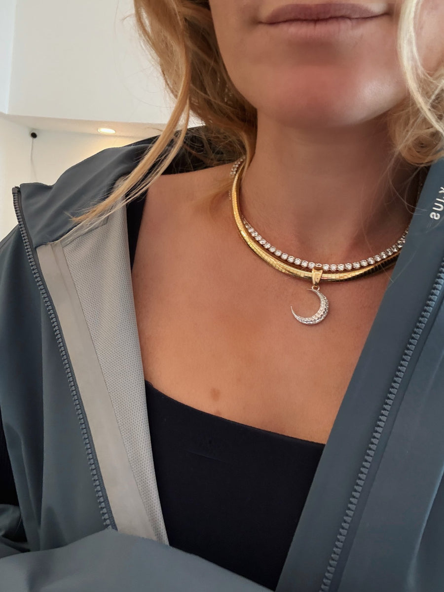 A gold collar with a crescent moon pendant