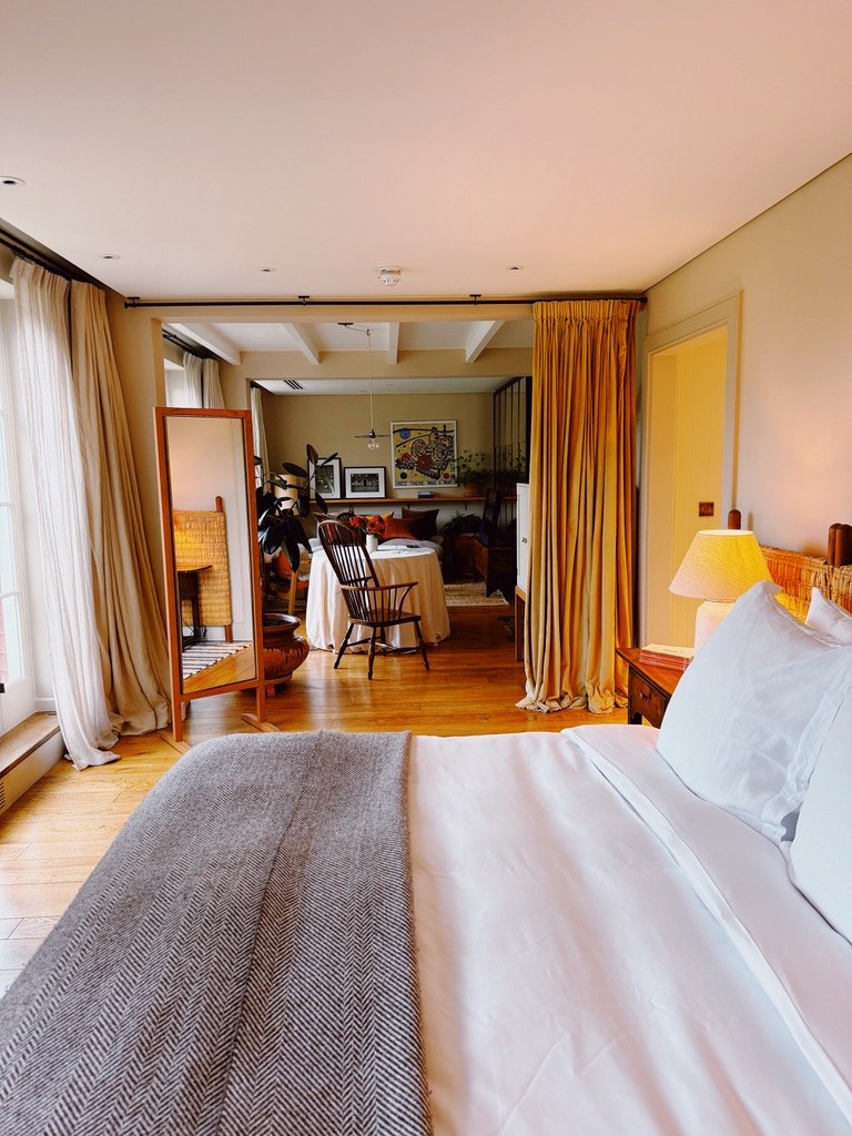 The bedroom, a pale bed and long curtains