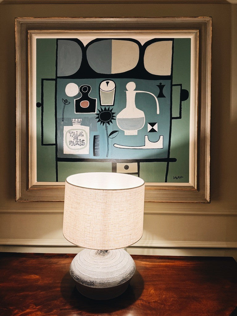A framed print above a white lamp