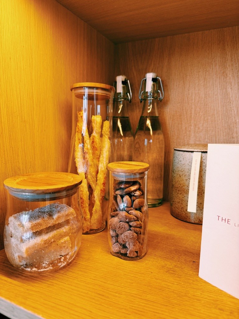 Jars of cookies and nuts in a lit cupboard