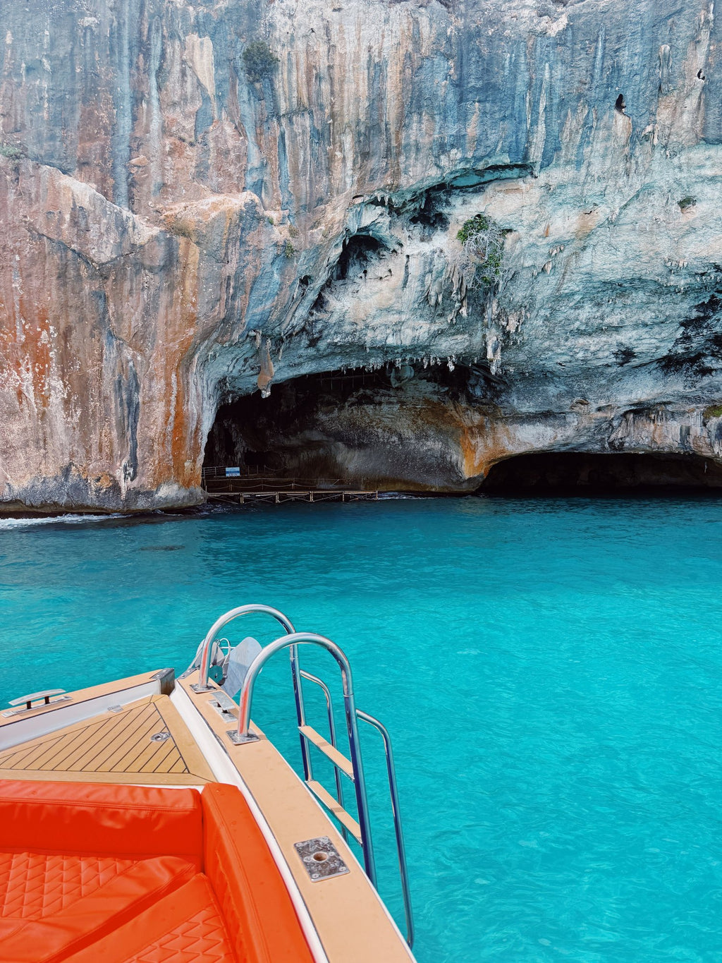 The bow of the day boat nosing toward a cave in the cliffs