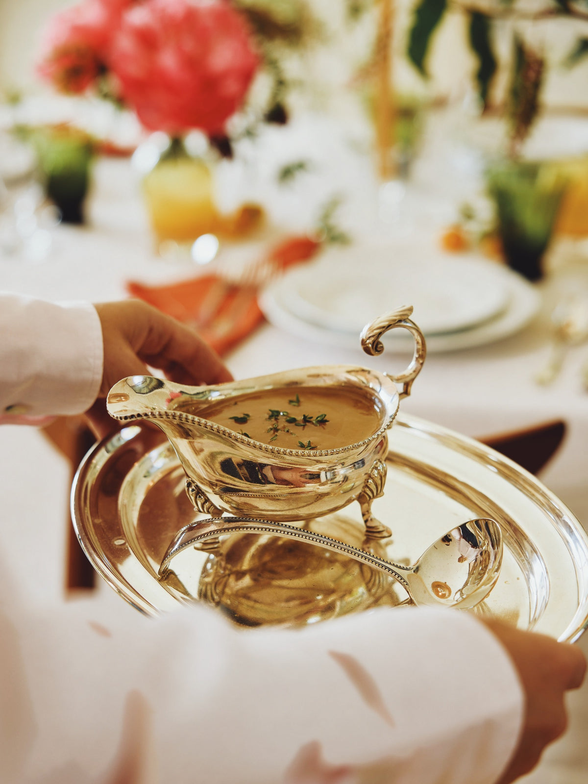 The gravy boat on its silver tray, carried past the set table