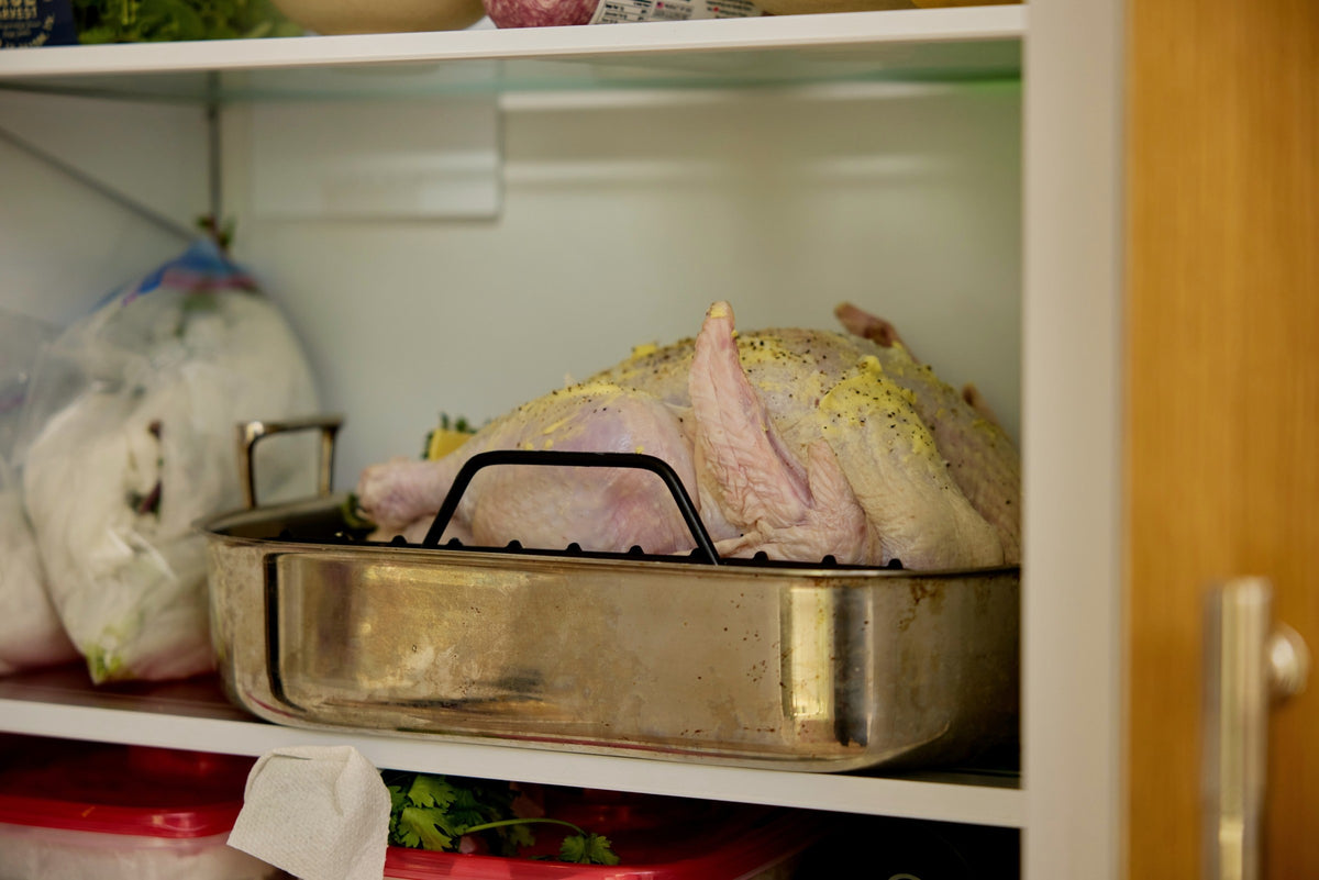 The turkey on the lowest shelf, on its tray