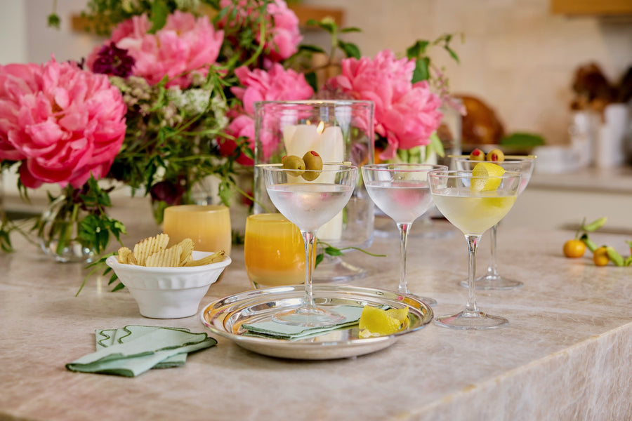 Martinis, olives and chips set out under peonies