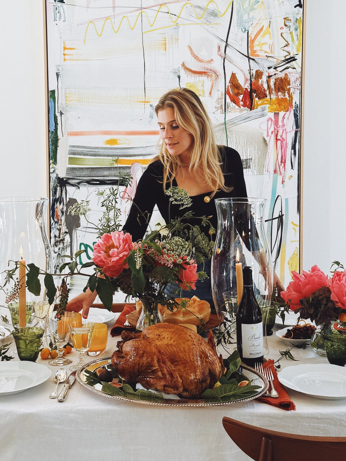 Lucy setting the Thanksgiving table under the woven pendant