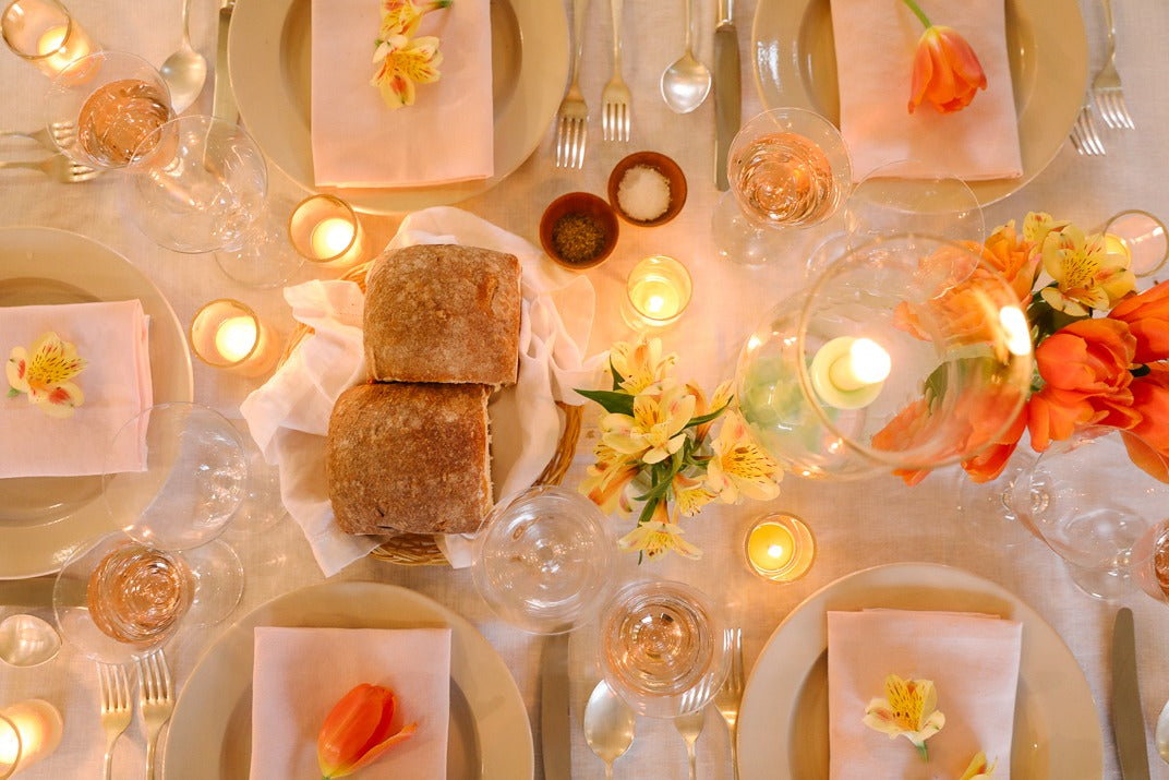 The Thanksgiving table set on Wednesday: tapers, peonies, green goblets and rust napkins on a pressed white cloth