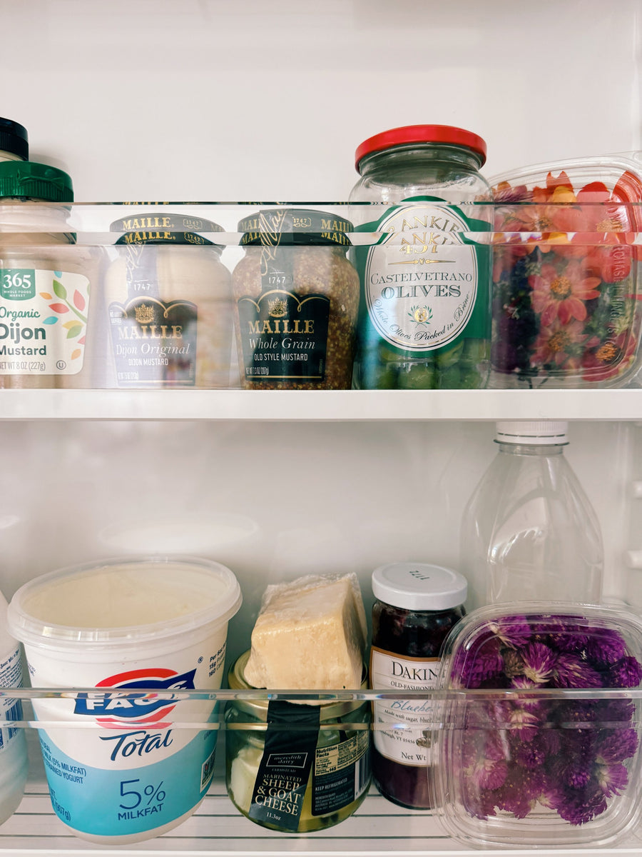 The fridge on Wednesday: Maille mustards, Castelvetrano olives, Fage, parmesan, marinated goat cheese, and boxes of flowers for the table