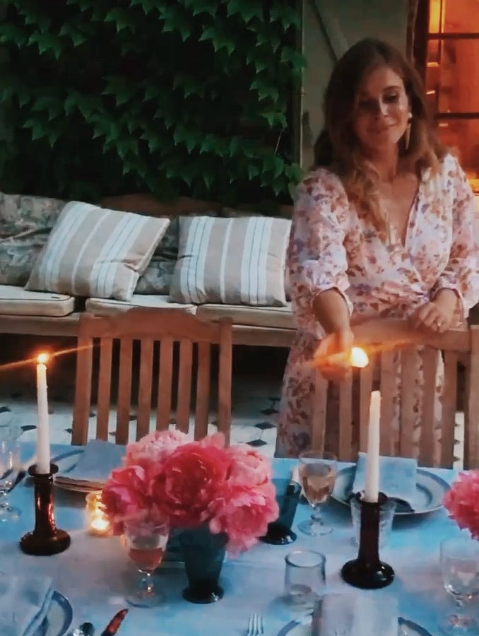Glass hurricanes, rosé and a pink rose on a blue and white cloth